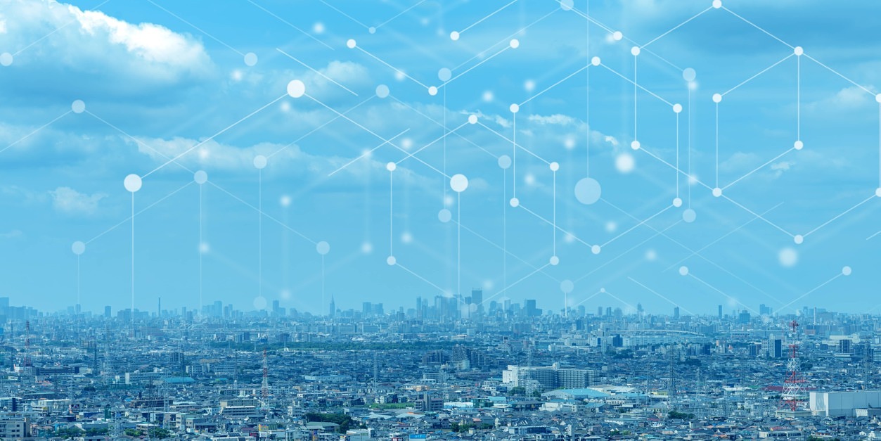 Stadtpanorama mit einer grafischen Darstellung miteinander verbundener Knoten und Verbindungen, das ein LPWAN für Massive-IoT-Anwendungen veranschaulicht